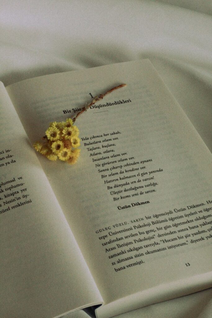 An open book with a yellow flower bouquet on the pages.